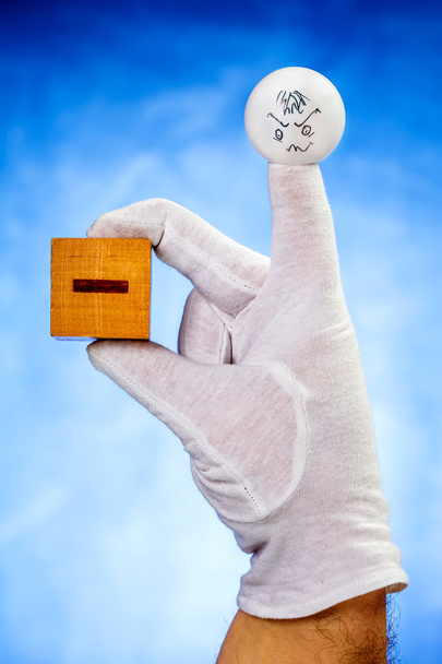 Marionnette à doigts tenant un cube en bois avec signe moins
 - Photo, image