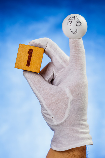 Un nombre sur cube en bois tenir par marionnette à doigt
 - Photo, image