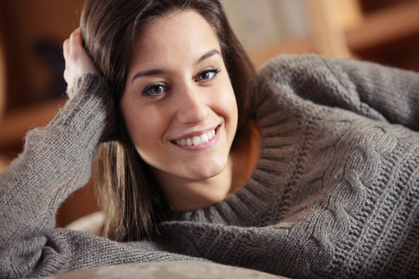 Portrait of a beautiful young woman on couch - Fotoğraf, Görsel