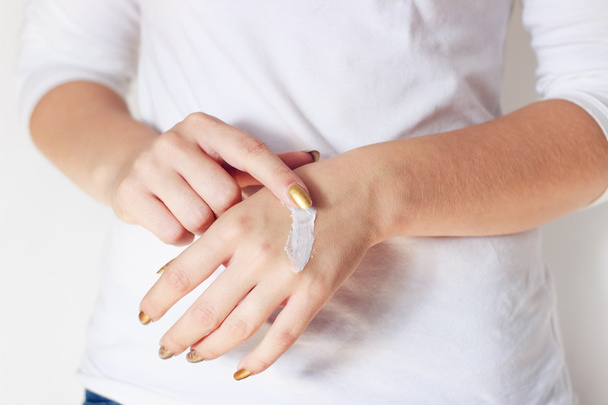Lichaamsdeel - jonge vrouw met crème op handen - Foto, afbeelding