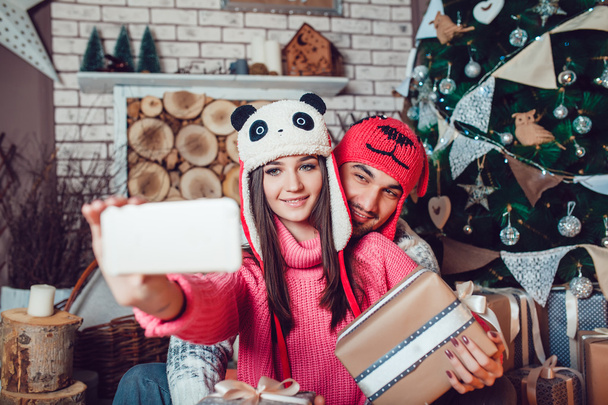 Couple in love in Christmas decorations make the selfie - Фото, изображение
