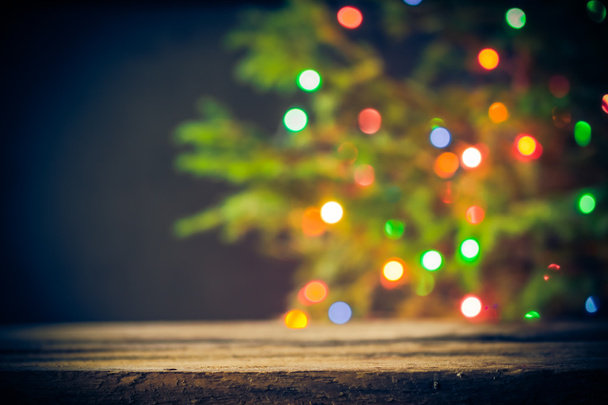 Feestelijke achtergrond houten tafel kerstboom lichten - Foto, afbeelding