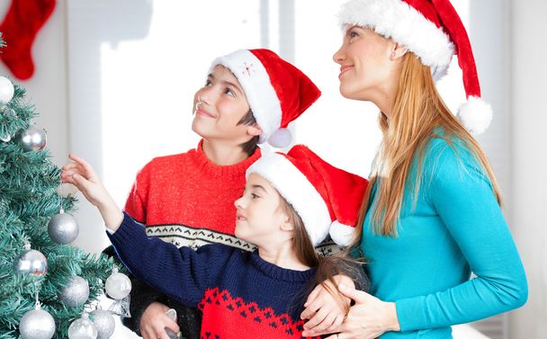 Family decorating Christmas tree - Valokuva, kuva