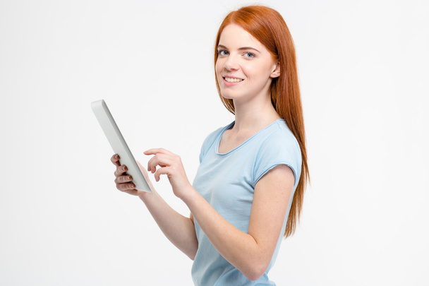 Mulher jovem alegre bonita segurando e usando tablet
  - Foto, Imagem