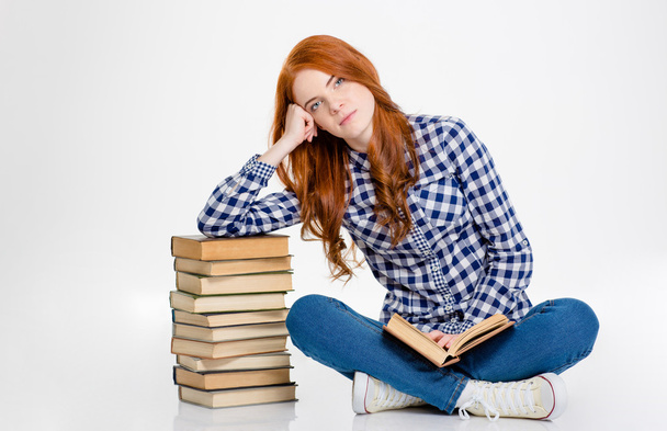 Thoghtful girl sitting  and leaning on stack of the books - Foto, Bild