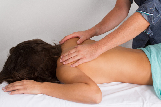 Rahat bir kadınla arka gövde üzerinde fizyoterapist tarafından masaj terapisi - Fotoğraf, Görsel