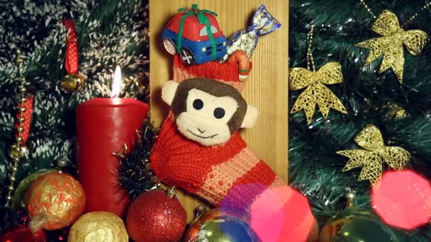 Fondo de Navidad con luces de vela y mono en calcetín rojo
. - Imágenes, Vídeo