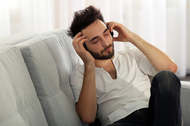 Young man listens music with headphones  - 写真・画像