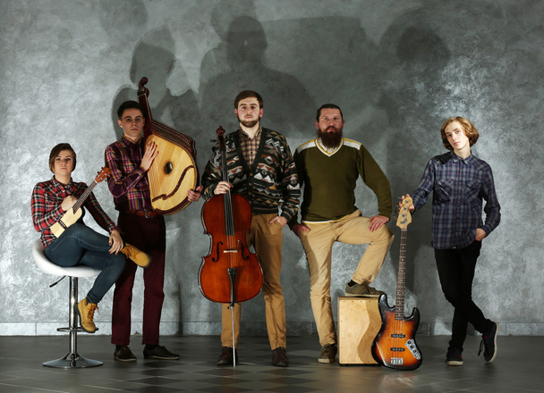 Musical band against grey wall  - Фото, изображение