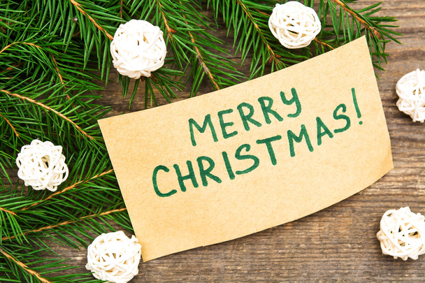 Greeting card "Merry Christmas" written on kraft paper with fir  - Photo, Image