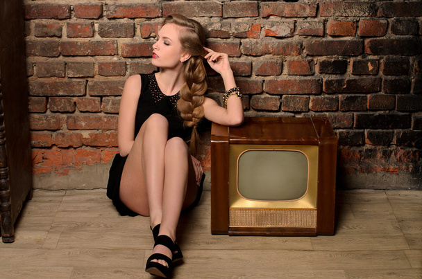 retro tv készülék közelében ült, fiatal érzéki nő - Fotó, kép