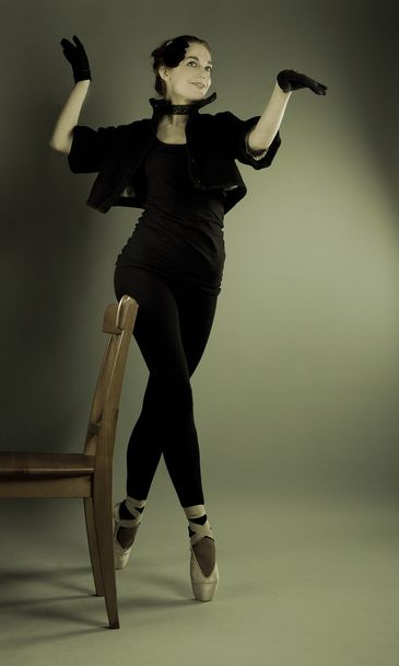Young ballerina performs exercises near the chair - Φωτογραφία, εικόνα