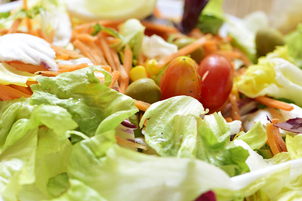 Grüner Salat mit Karotten, Oliven, Kirschtomaten und Mais - Foto, Bild