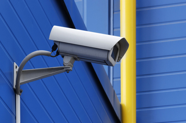 Câmera de vigilância ao lado de tubo amarelo
 - Foto, Imagem