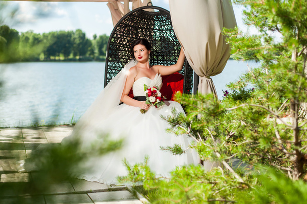 Bride sitting in decorative pavilion - Foto, Bild
