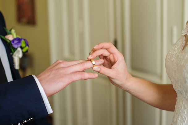 Наречений одягає перстень на руку в день весілля
 - Фото, зображення