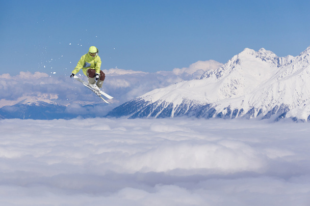 山の上で空飛ぶスキーヤー。極端なスポーツ. - 写真・画像