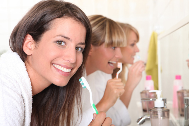 Three young women brushing their teeth - Fotó, kép