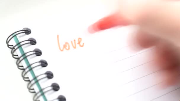 Upływ czasu pisania wyrazu miłości wiele razy z czerwonym znacznikiem - Materiał filmowy, wideo