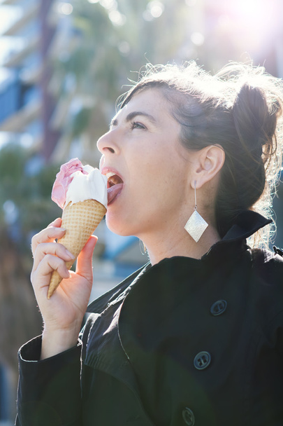 Femme lécher une crème glacée avec éruption de soleil derrière ses cheveux
 - Photo, image