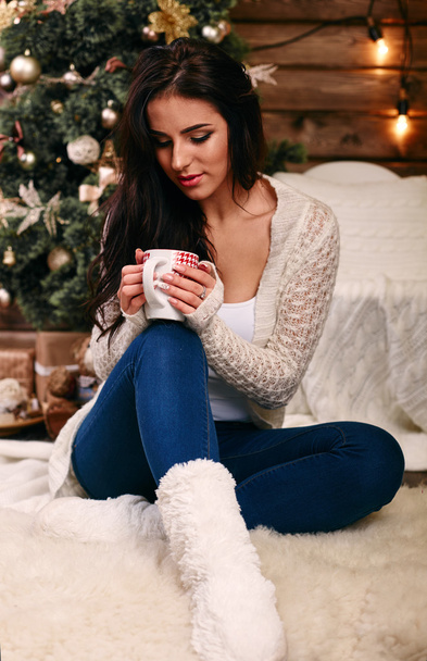 Woman holding a red cup of hot drink. Drink hot tea or coffee in the morning cool. Traditional autumn or winter warming drin - Photo, image