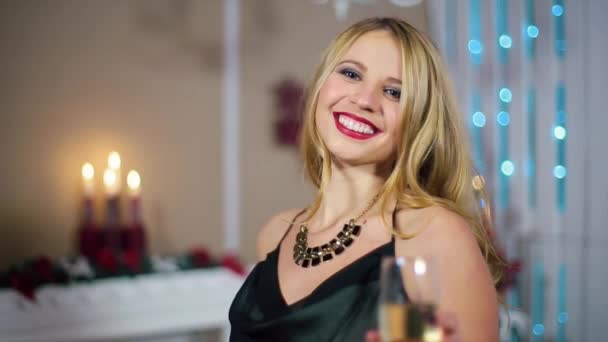 Beautiful Young Girl Holds Glass of Wine, in a white room with Christmas tree - Séquence, vidéo