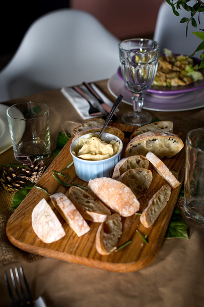 Pane fresco e burro fatto in casa sul tavolo da pranzo decorato
. - Foto, immagini