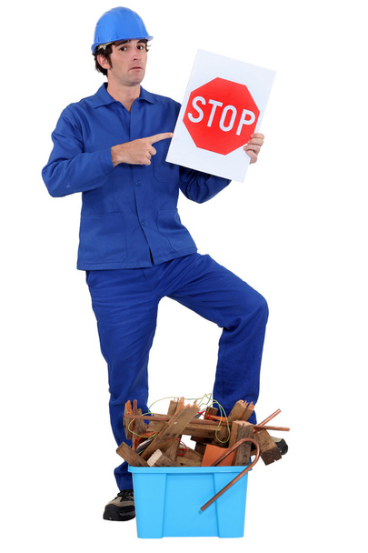 Man stood holding stop sign by crate of refuge - Φωτογραφία, εικόνα