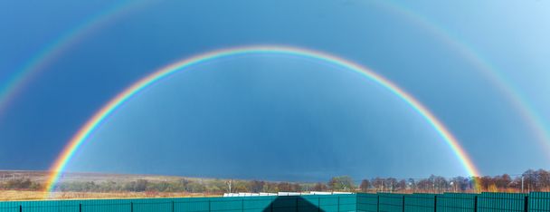 Belo arco-íris completo acima do campo agrícola na primavera
 - Foto, Imagem