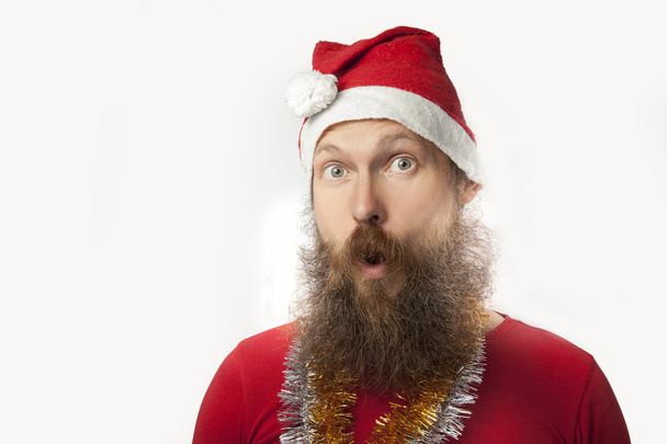 happy funny santa claus with real beard and red hat and shirt making crazy face and smiling, looking and camera. - Photo, image