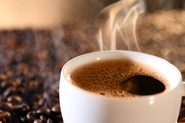 Cup of hot coffee on coffee beans background - Photo, Image