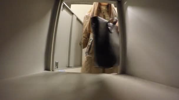 Γυναίκα βάζει την τσάντα σε μια αίθουσα ντουλάπι αποθήκευσης - Πλάνα, βίντεο