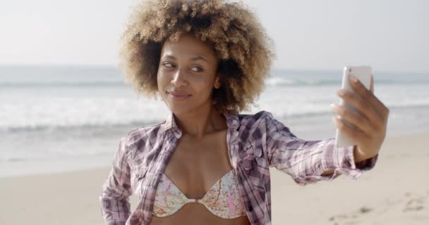 Mujer posando para tomar un selfie en la playa
 - Imágenes, Vídeo