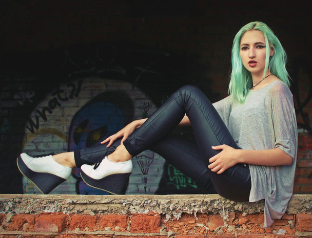 Young woman sitting on a floor of abandoned building - Φωτογραφία, εικόνα