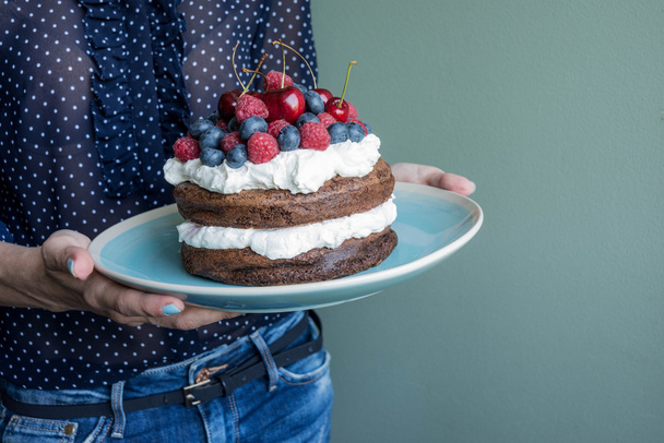 prachtige cake met frambozen, kersen, bosbessen en room - Foto, afbeelding