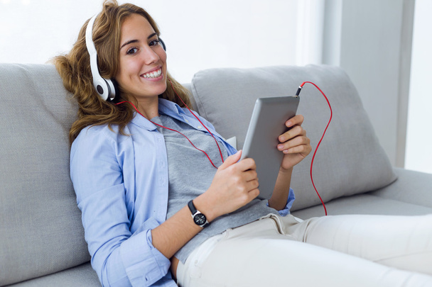 Beautiful young woman listening to music with digital tablet at  - Foto, Imagen