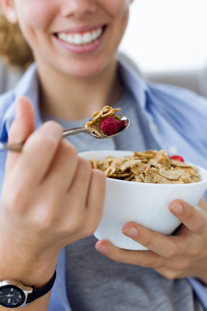 Beautiful young woman eating cereals at home. - Foto, Bild