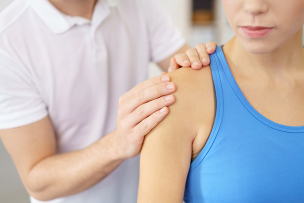 Therapeut masseren de schouder van een patiënt - Foto, afbeelding