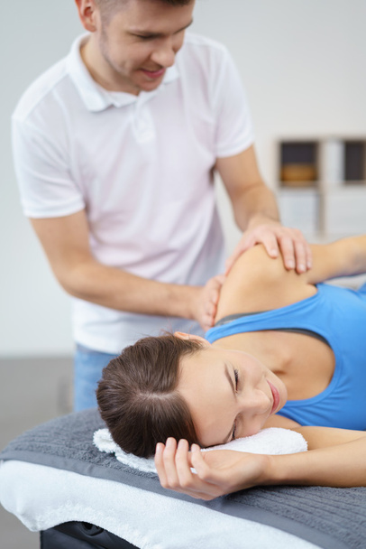 Male Osteopath Massaging the Shoulder of Patient - 写真・画像