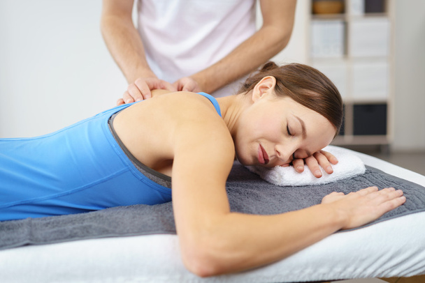 Woman having a Massage on her Injured Upper Back - Foto, imagen