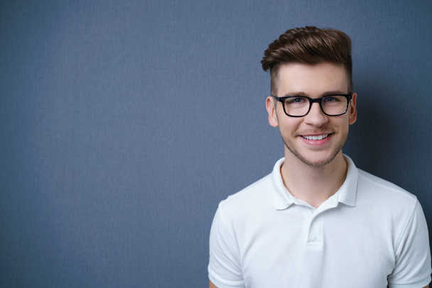 Smiling friendly attractive young man with a modern trendy hairstyle - Zdjęcie, obraz