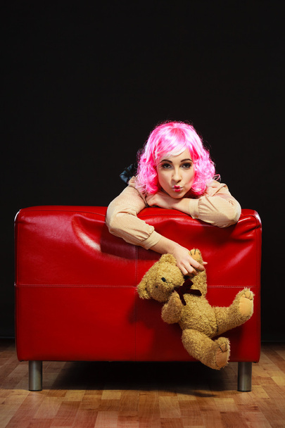 childlike woman and teddy bear sitting on couch - Zdjęcie, obraz