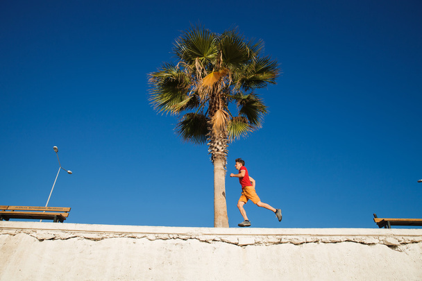 Чоловік біжить над блакитним небом
 - Фото, зображення