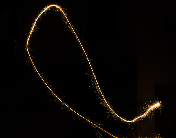 sparkler light trail in dark environment using slow shutter speed - Фото, изображение