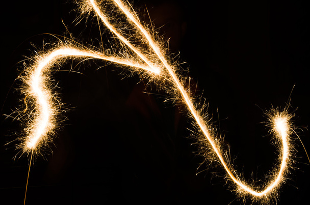 sparkler light trail in dark environment using slow shutter speed - Valokuva, kuva