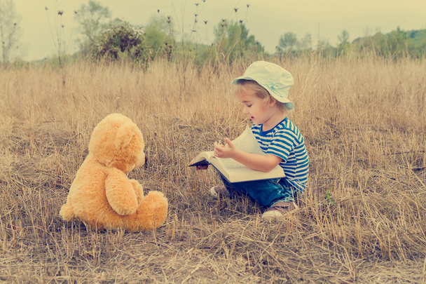 Aranyos lány olvasó könyv mackó - Fotó, kép