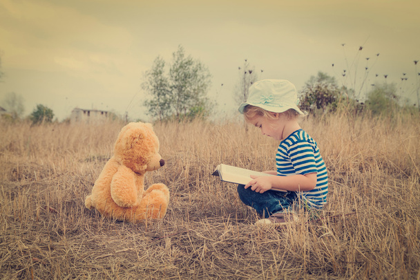 Leuk meisje lezen boek Teddy bear - Foto, afbeelding