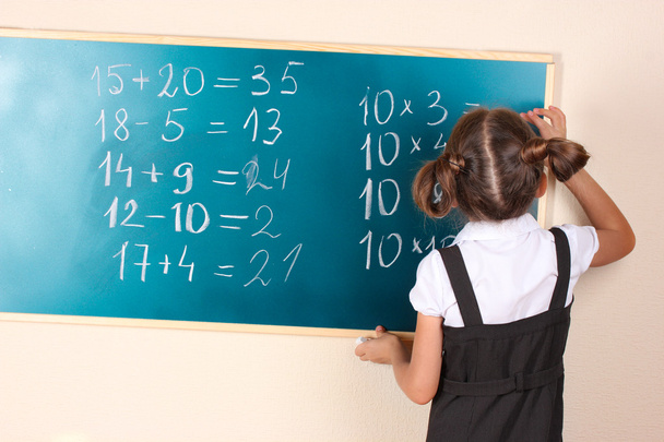 Beautiful little girl writing on classroom board - Photo, image