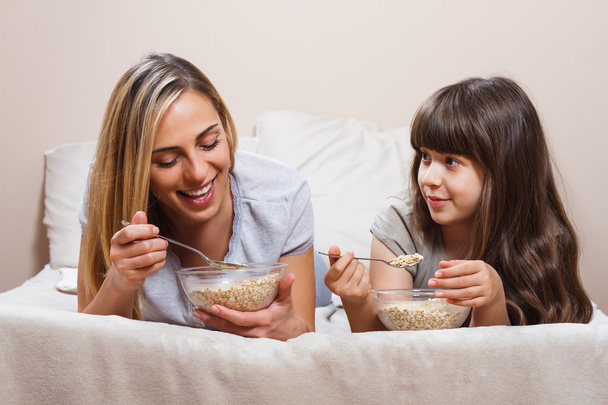 mother and daughter eating breakfast - Photo, image