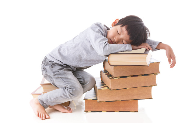 Asiático bonito menino sentado e dormindo na pilha de livros
. - Foto, Imagem
